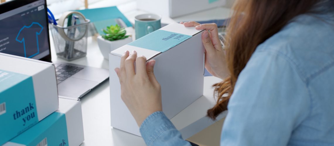 Young attractive beautiful hipster asia female packing product small business parcel order online retail store for delivery to customer. SME owner work preparing dropshipping box at home office.